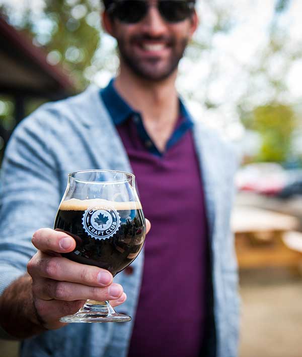 person posing with glass of beer